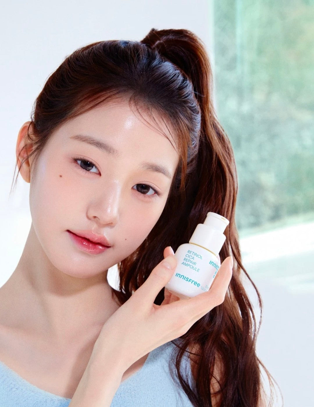 Woman applying Innisfree Retinol Cica Repair Ampoule to skin