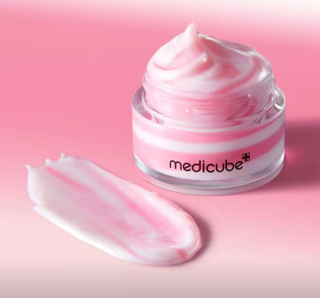 Jar of Medicube cream with pink cream on a pink background