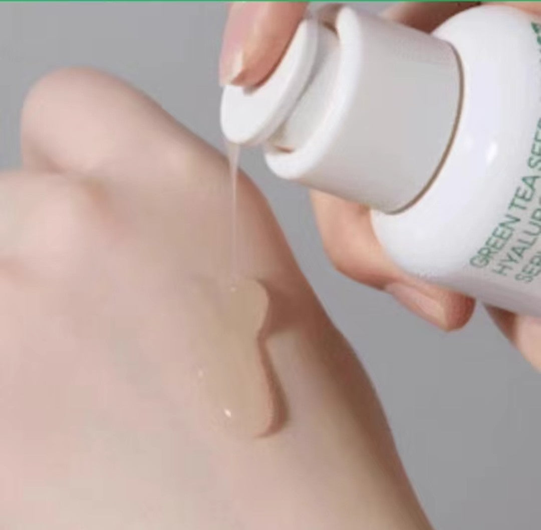 Hand applying a white cream to another hand against a neutral background