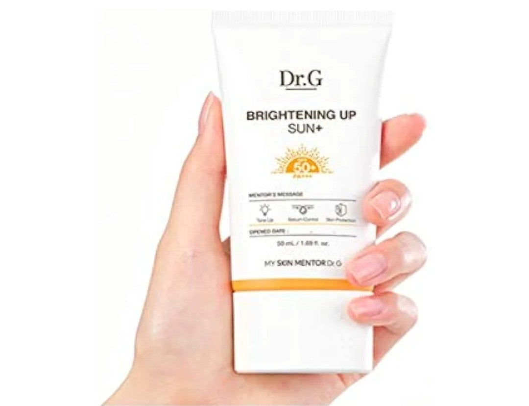 Hand holding a Dr.G sunscreen cream with a white background