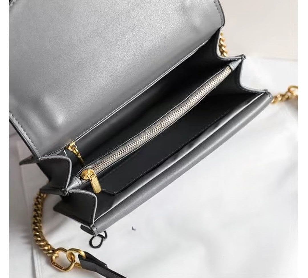 "Interior view of grey crocodile-embossed shoulder bag with gold chain and zip compartments"