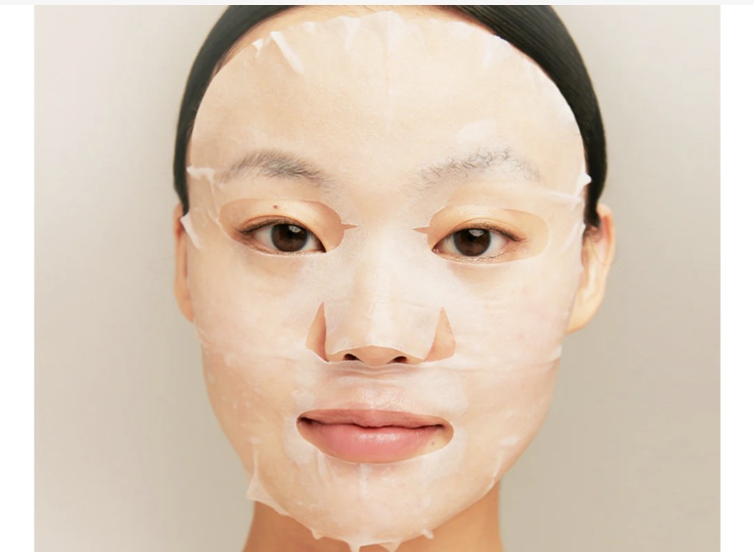 Person wearing a face mask with a neutral background