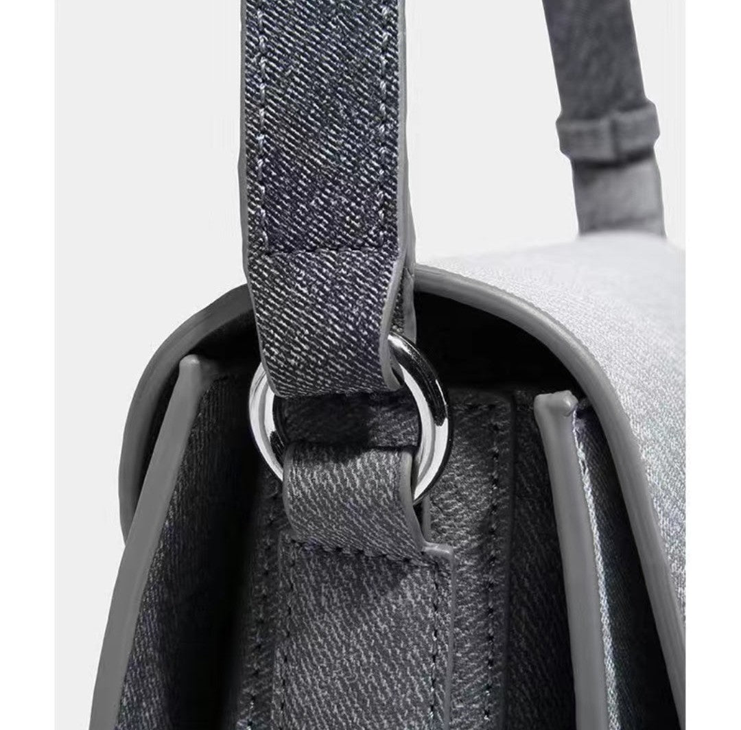 Close-up of a gray backpack with a strap and metal buckle on a white background