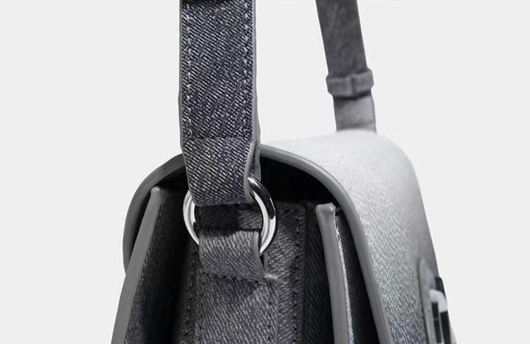 Close-up of a gray backpack with a strap on a light gray background