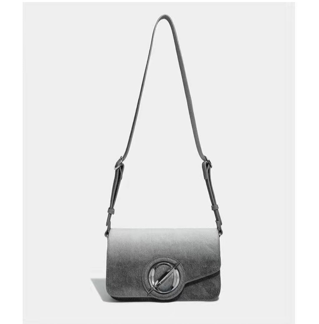 Gray shoulder bag with a circular clasp on a white background