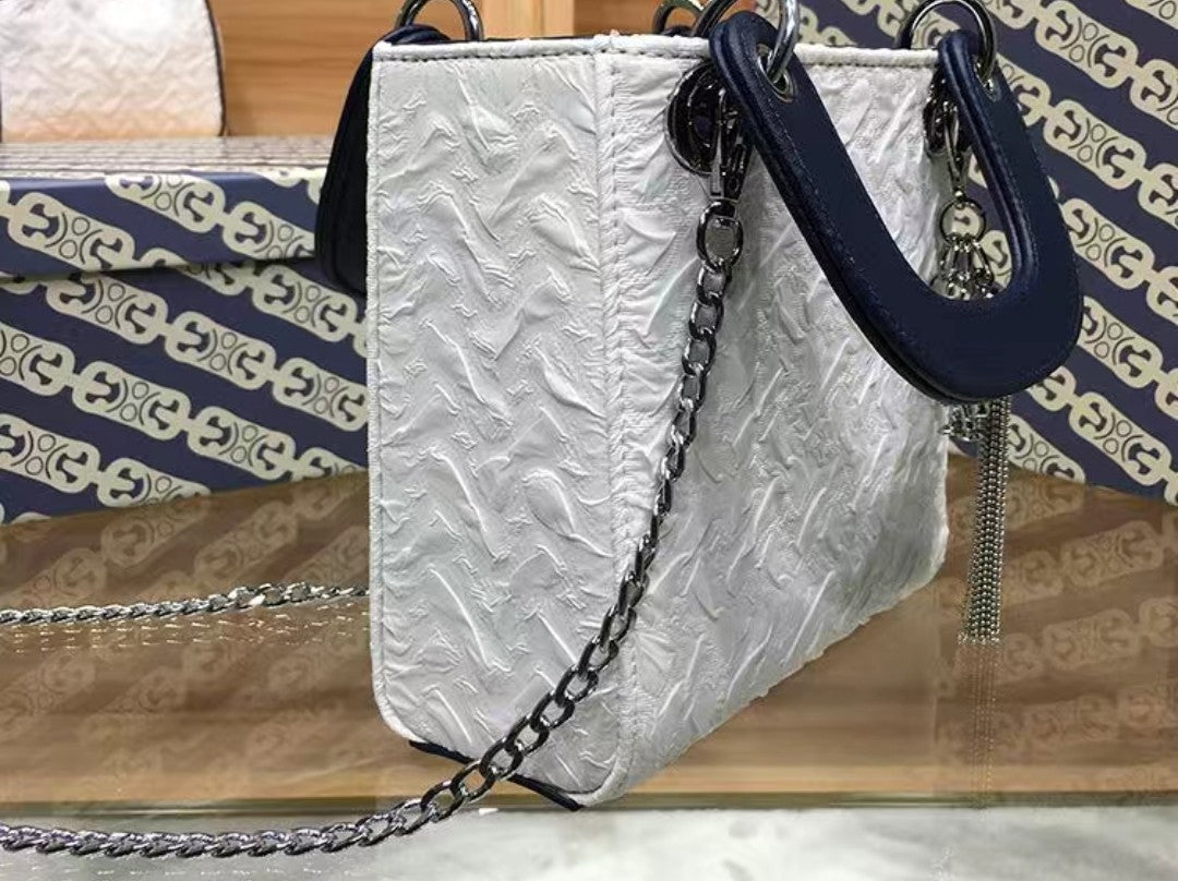 Close-up of silver tassel and keyring charm on GlowBags elegant mini handbag