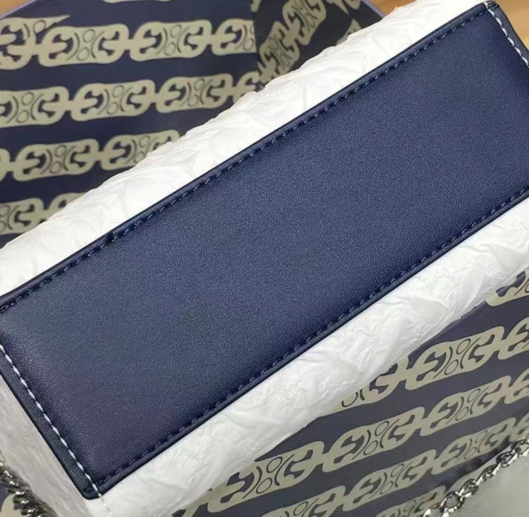 Close-up of navy PU leather handle on GlowBags elegant white mini handbag