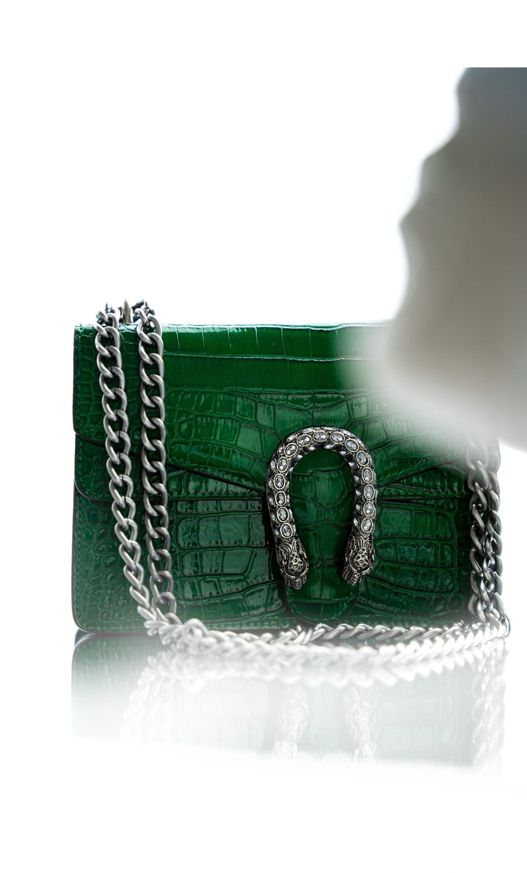 Green handbag with silver chain on a white background