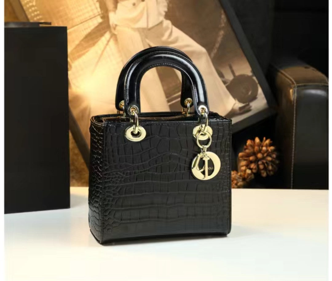 Black handbag with gold accents on a white surface