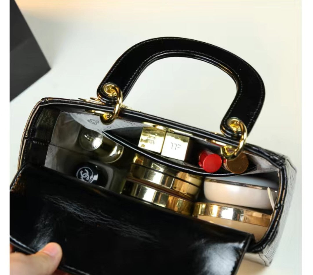 Black handbag with gold accents on a white background
