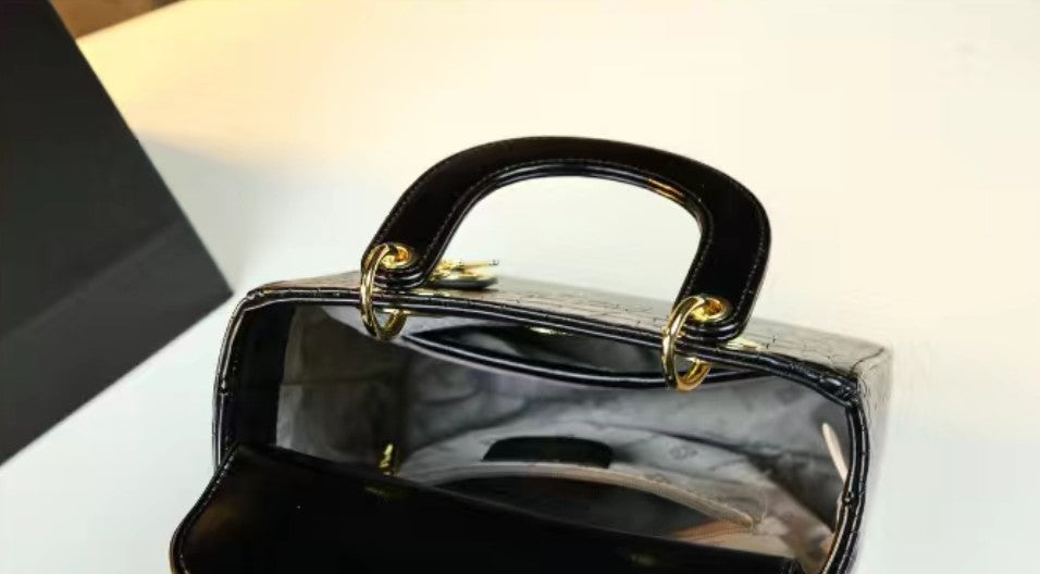 Black handbag with gold accents on a white background