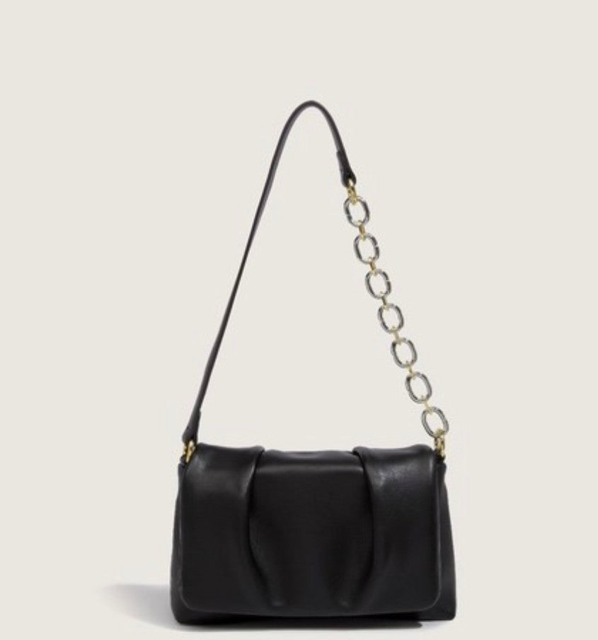 Black handbag with a chain strap on a light gray background
