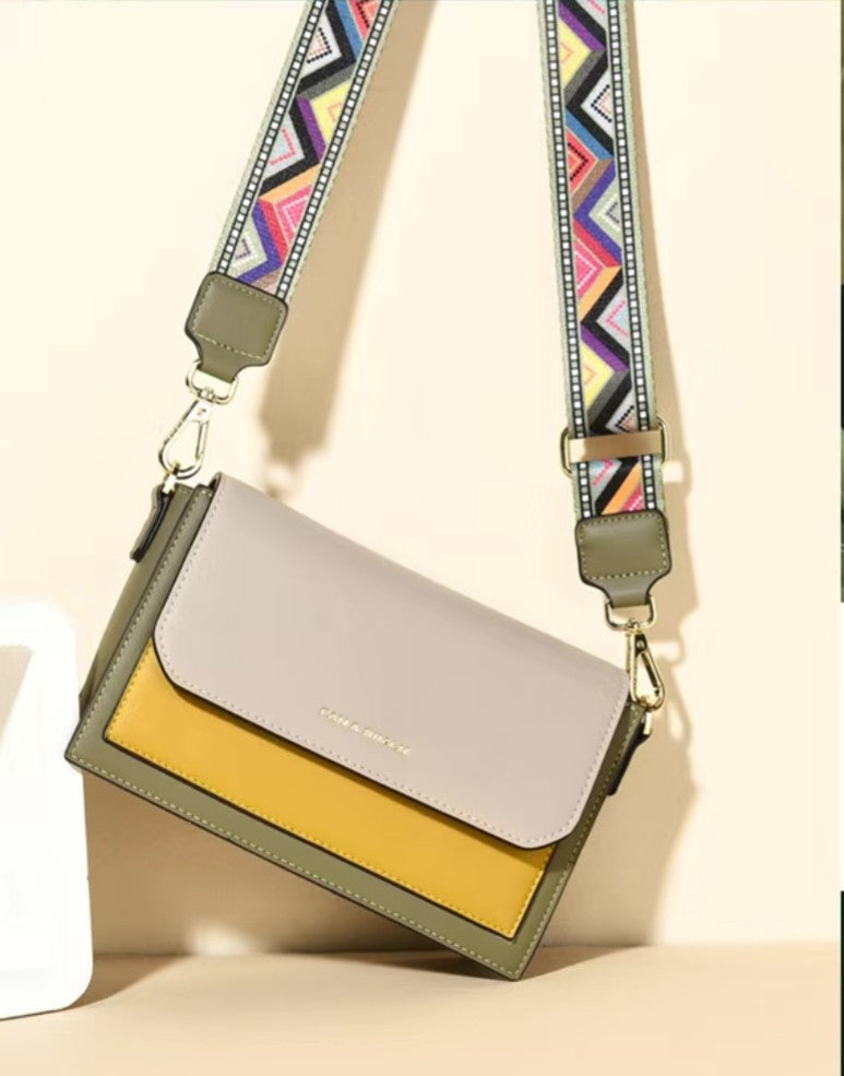 Crossbody bag with a colorful strap on a beige background