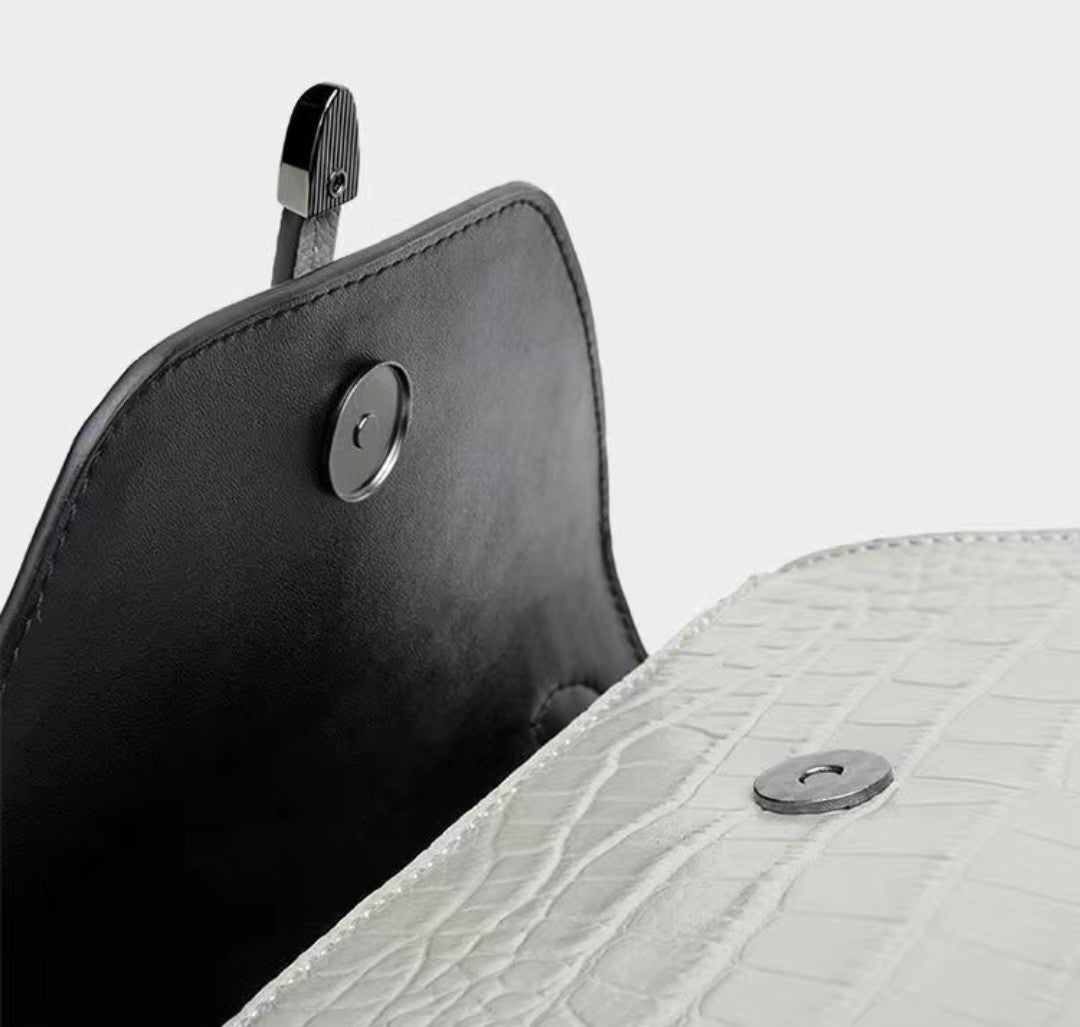 Close-up of a black leather product with a metal clip on a white background