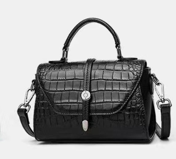 Black handbag with crocodile texture on a white background