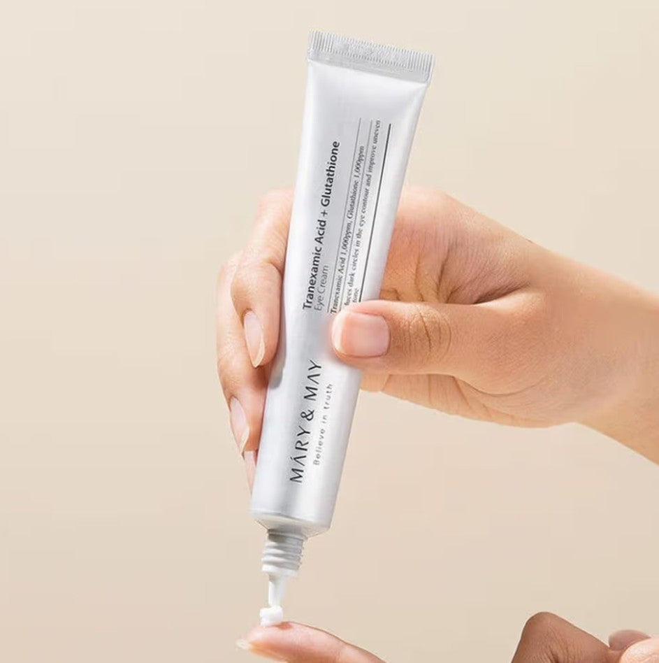 Hand holding a tube of skincare product with a beige background