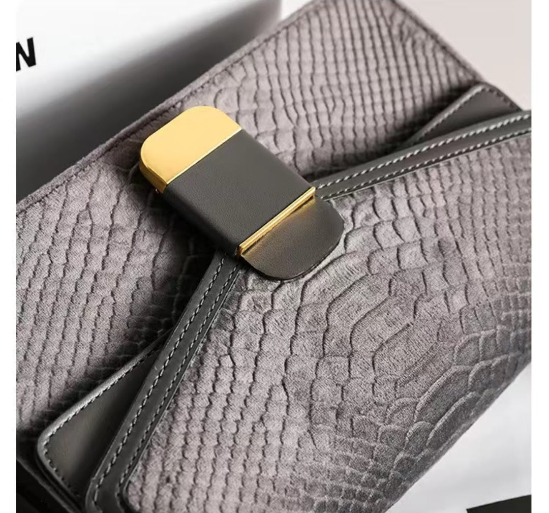 Gray textured clutch bag with a gold and black clasp