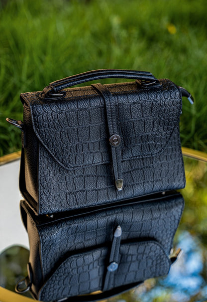 Black textured backpack on a blurred natural background