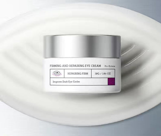 Jar of firming and repairing eye cream with silver lid and white cream texture, labeled to reduce dark circles and puffiness, 30g."