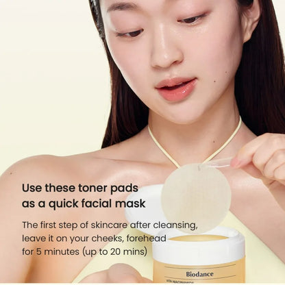 Woman using toner pads with Biodance product on a beige background
