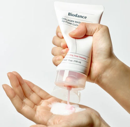 Hand holding a Biodance skincare product and squeezing foam into another hand on a white background