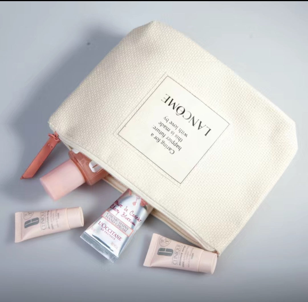 L'Occitane cosmetic bag with products on a gray background