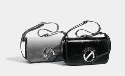 Two black handbags with metallic accents on a light gray background