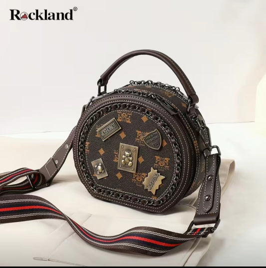 Brown patterned handbag with a strap on a white background, featuring the Rockland brand.