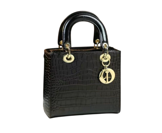 Black crocodile-patterned handbag with gold hardware on a white background