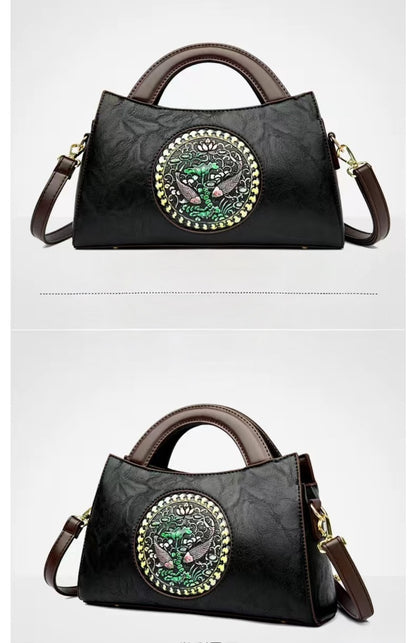 Black handbag with decorative emblem on a white background