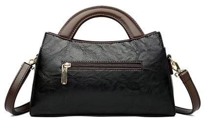 Black handbag with brown accents on a white background