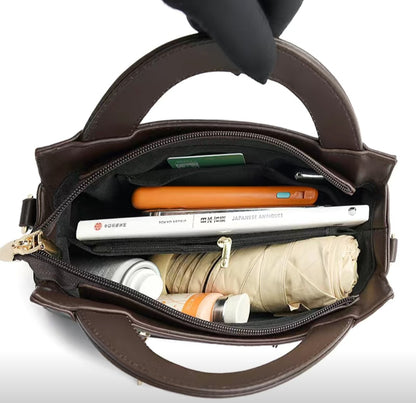 Brown handbag with items like a phone, books, and an umbrella inside on a white background