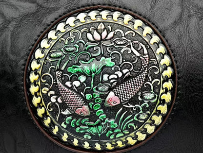 Decorative round emblem with fish and lotus design on a textured surface
