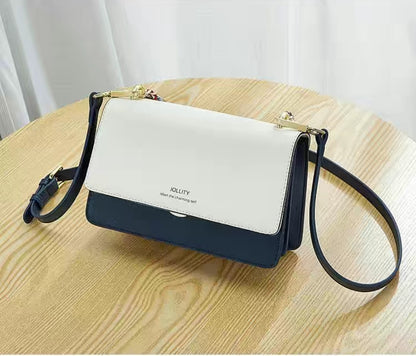 Two-tone handbag with white top section and navy bottom section on a wooden table.