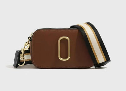 Brown camera bag with a striped strap on a light gray background
