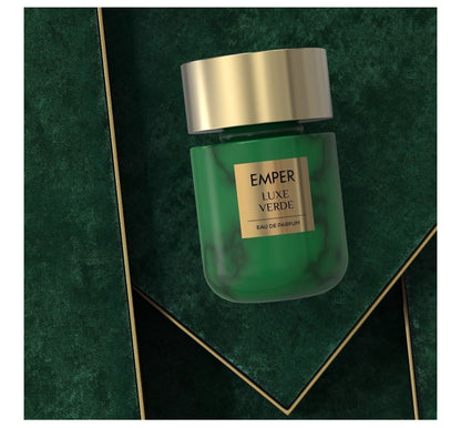 Green perfume bottle with gold cap on a green textured background
