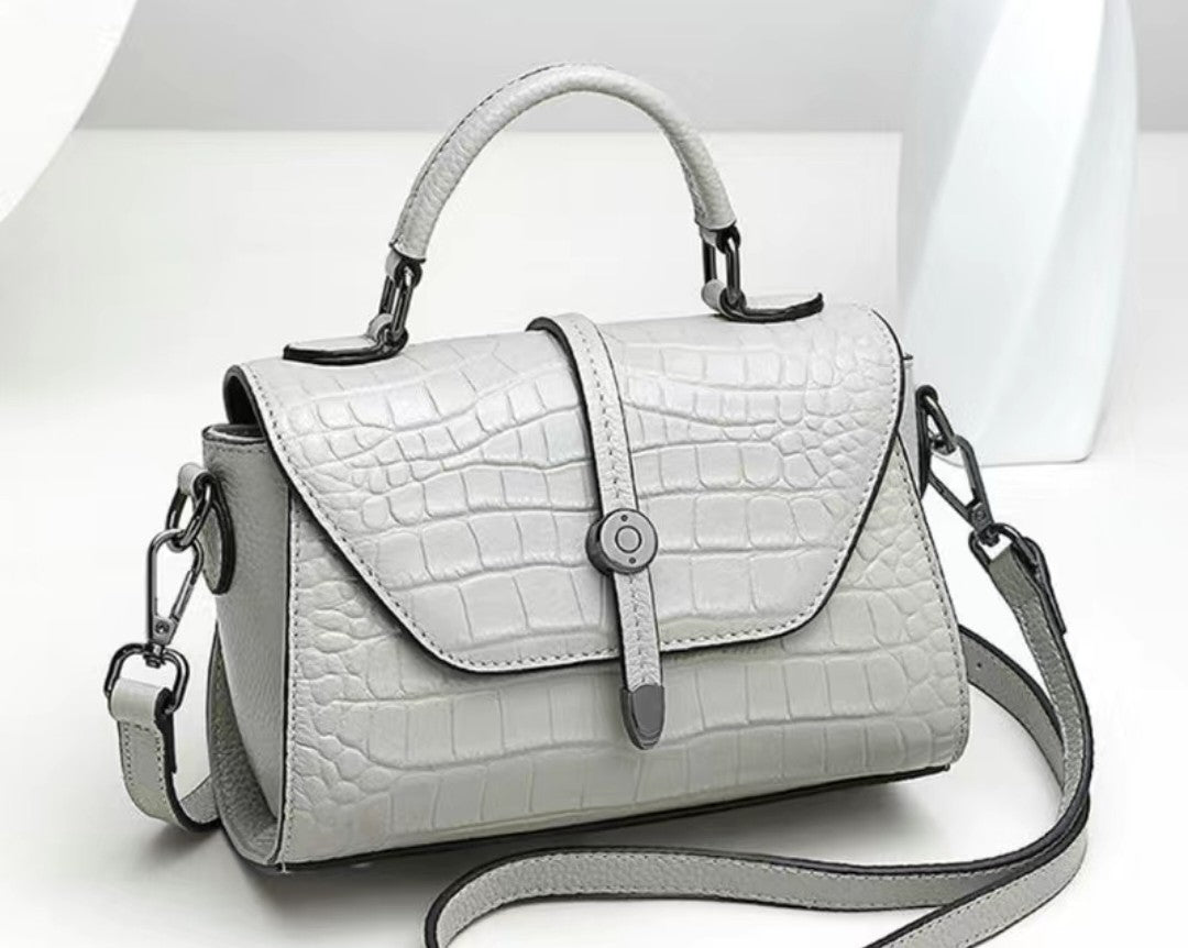 White handbag with crocodile texture on a white background