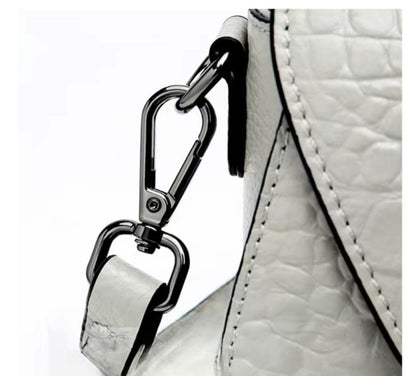 Close-up of a white textured handbag with a metal clasp on a white background