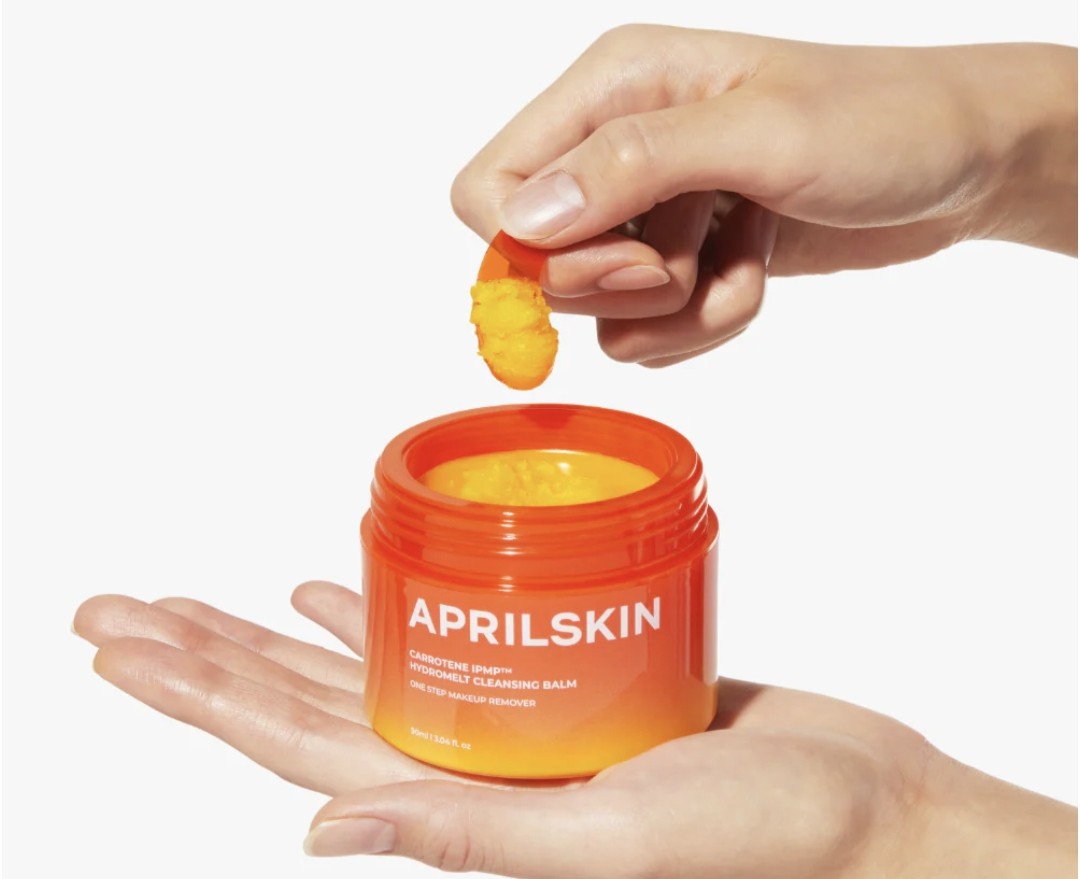 Person using APRILSKIN cleansing balm with a white background
