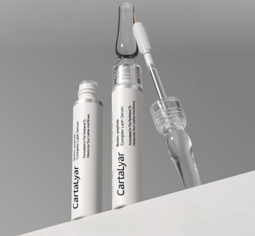 Two skincare bottles with a dropper on a gray background
