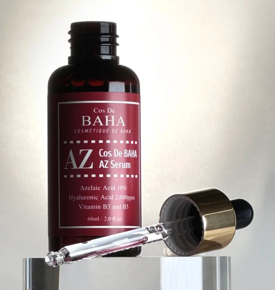 Cosmetic serum bottle with dropper on a reflective surface