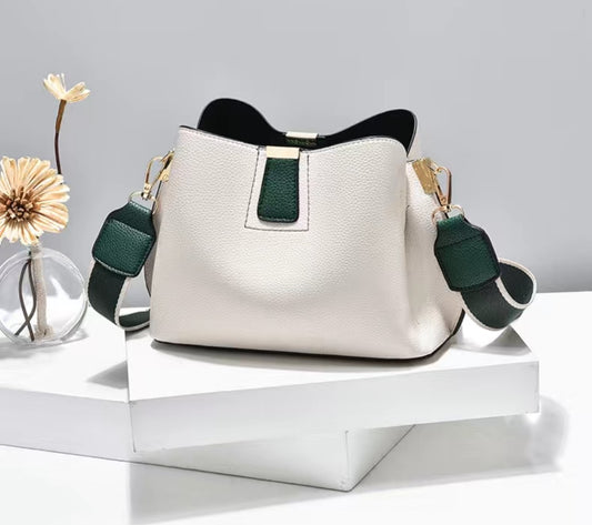 White handbag with green accents on a white surface