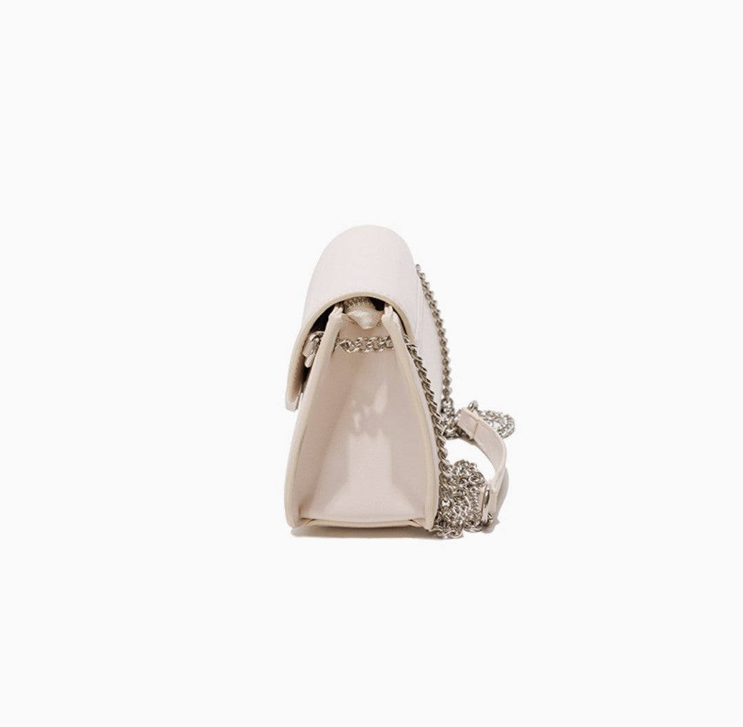 White handbag with decorative chain on a white background