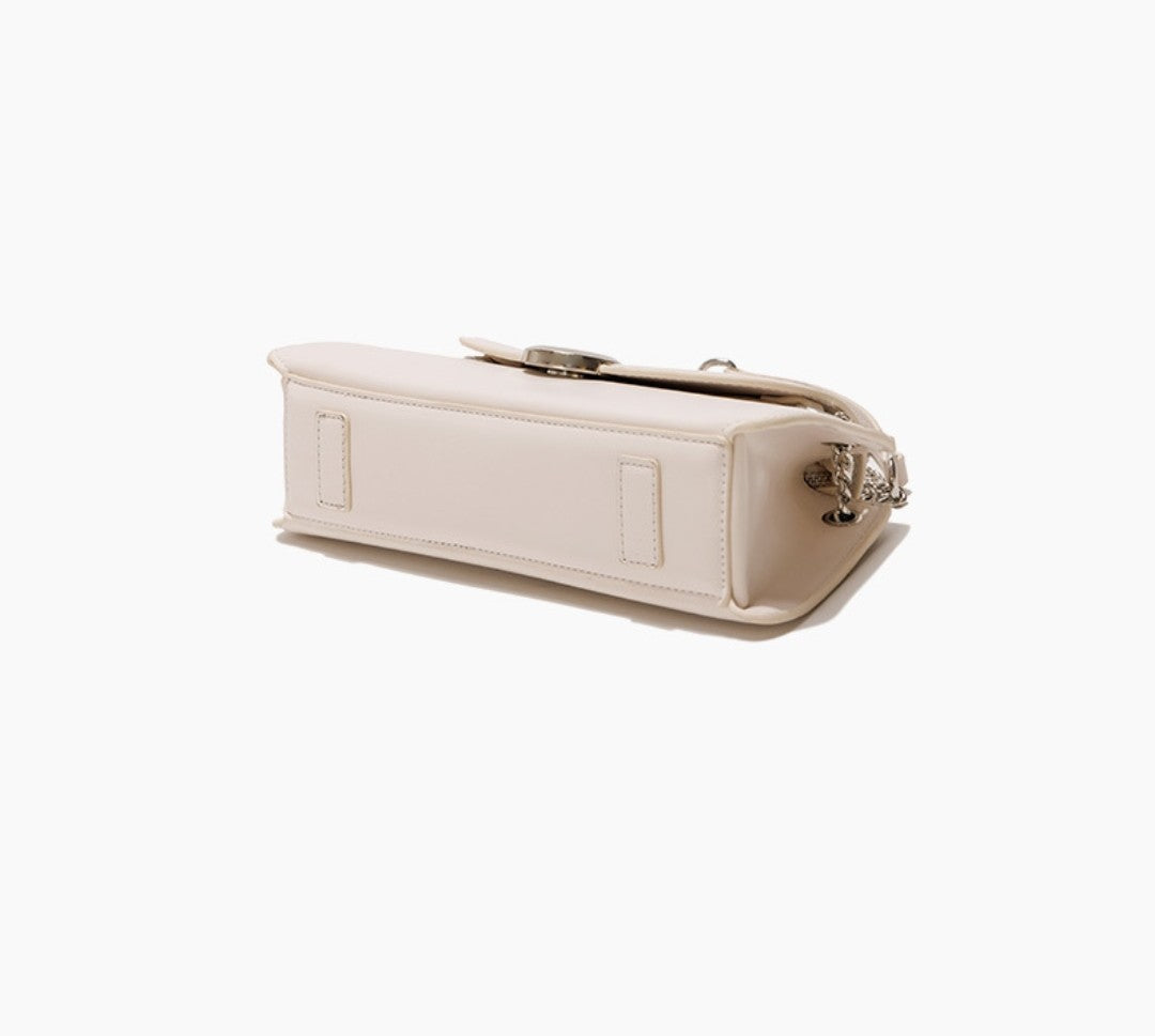 Beige handbag with a decorative clasp on a white background