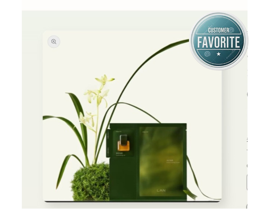 Green perfume bottle with packaging and decorative plant on a white background