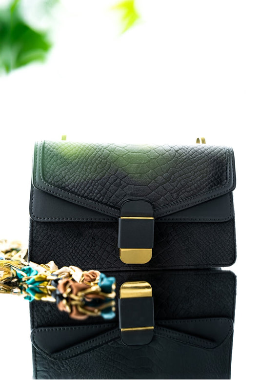 Black and green handbag with gold accents on a white background