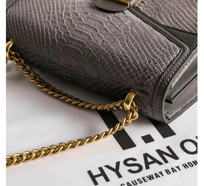 Gray textured handbag with a gold chain on a Hysan One Causeway Bay Hong Kong background
